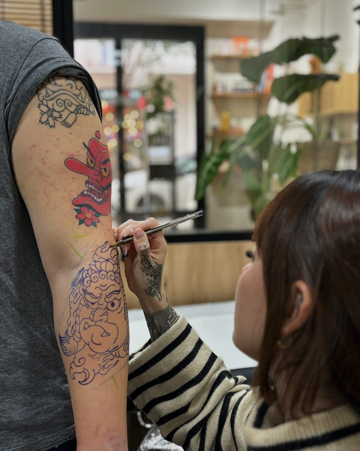 Tatuadora dibujando el diseño sobre el brazo antes de tatuar