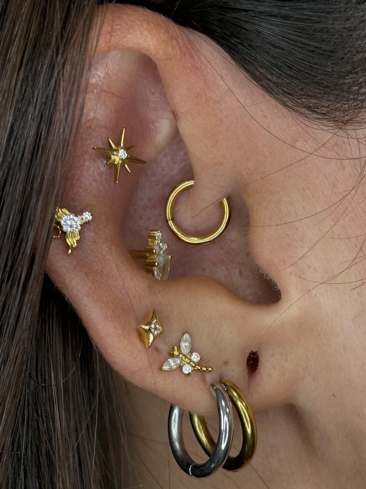 Piercings daith, conch y lóbulos con joyas doradas