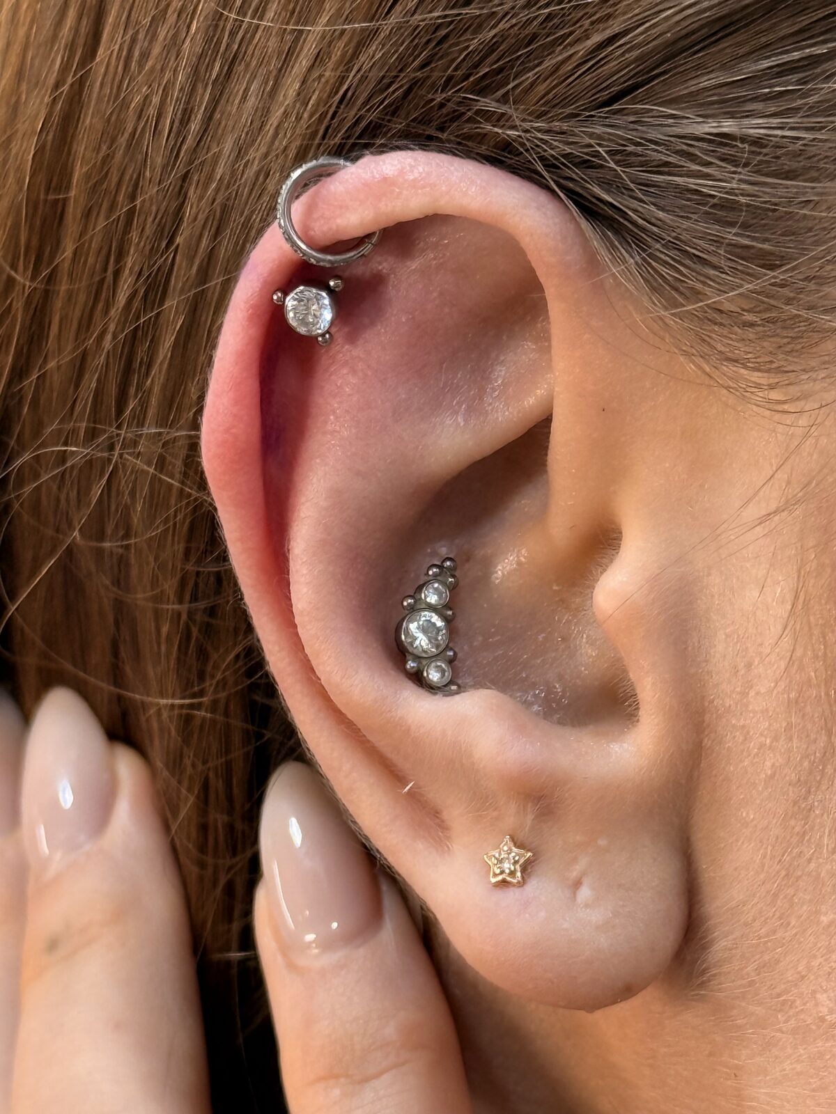 Piercings helix y conch con joyas plateadas