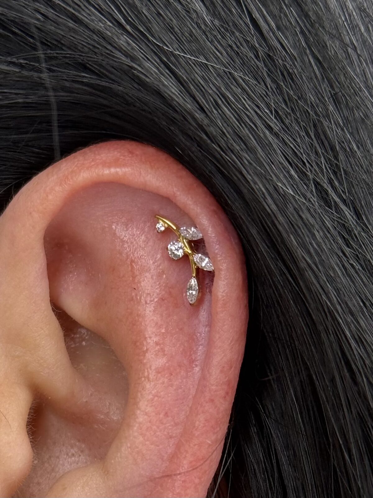 Piercing helix con joya de flor dorada