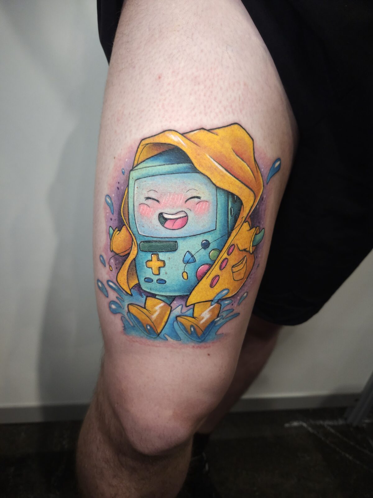 BMO de Hora de Aventuras con chubasquero amarillo en el muslo
