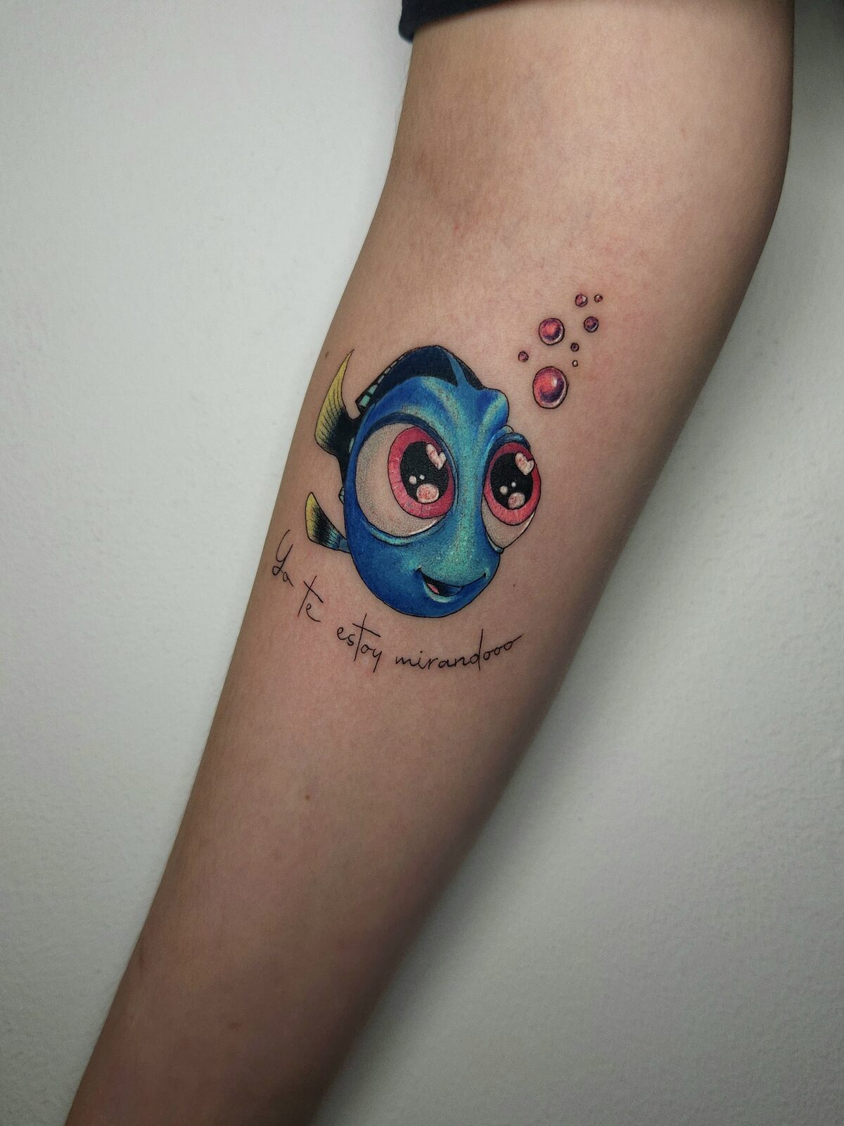 Dory de Buscando a Nemo con frase en el antebrazo