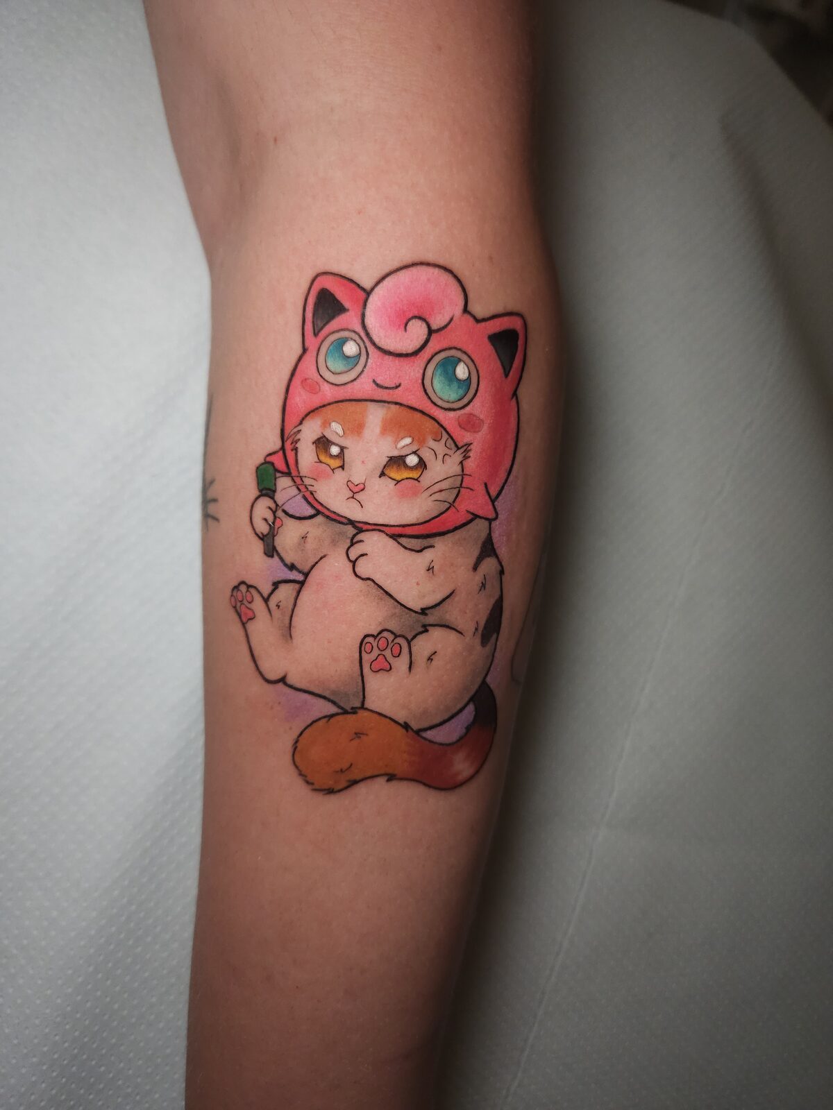 Gato con gorro de Jigglypuff de Pokémon en la pierna