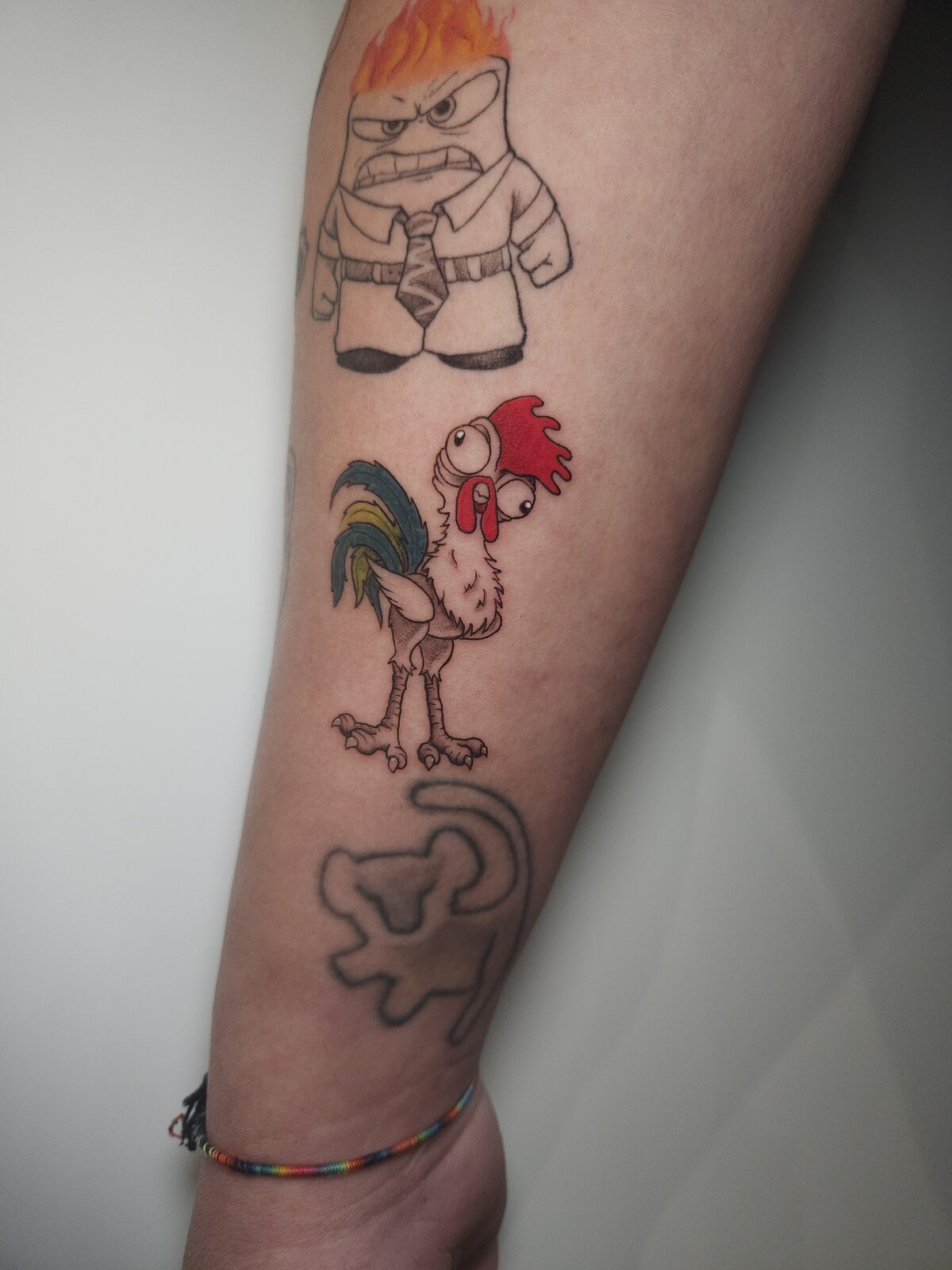 Heihei de Vaiana junto a otros personajes en el antebrazo