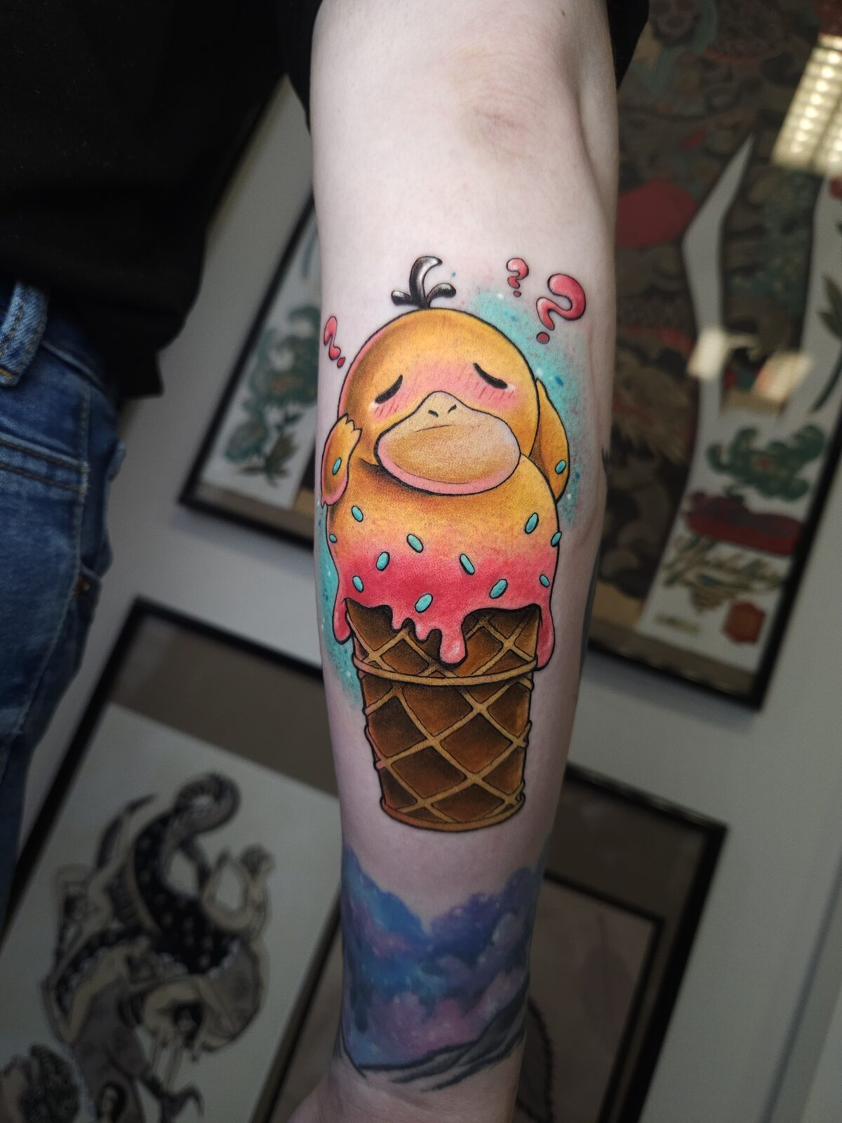 Psyduck de Pokémon dentro de un cucurucho de helado en el antebrazo