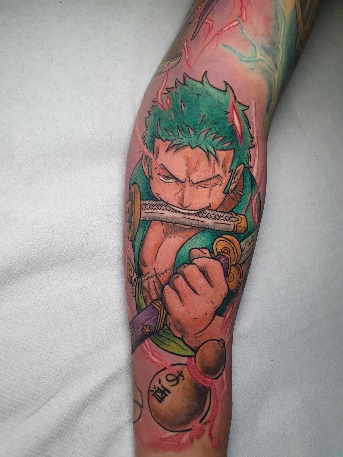 Zoro de One Piece con la espada en la boca en el brazo