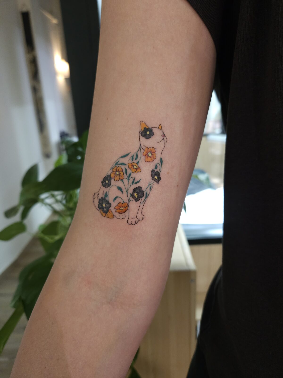 Gato con estampado de flores en el brazo