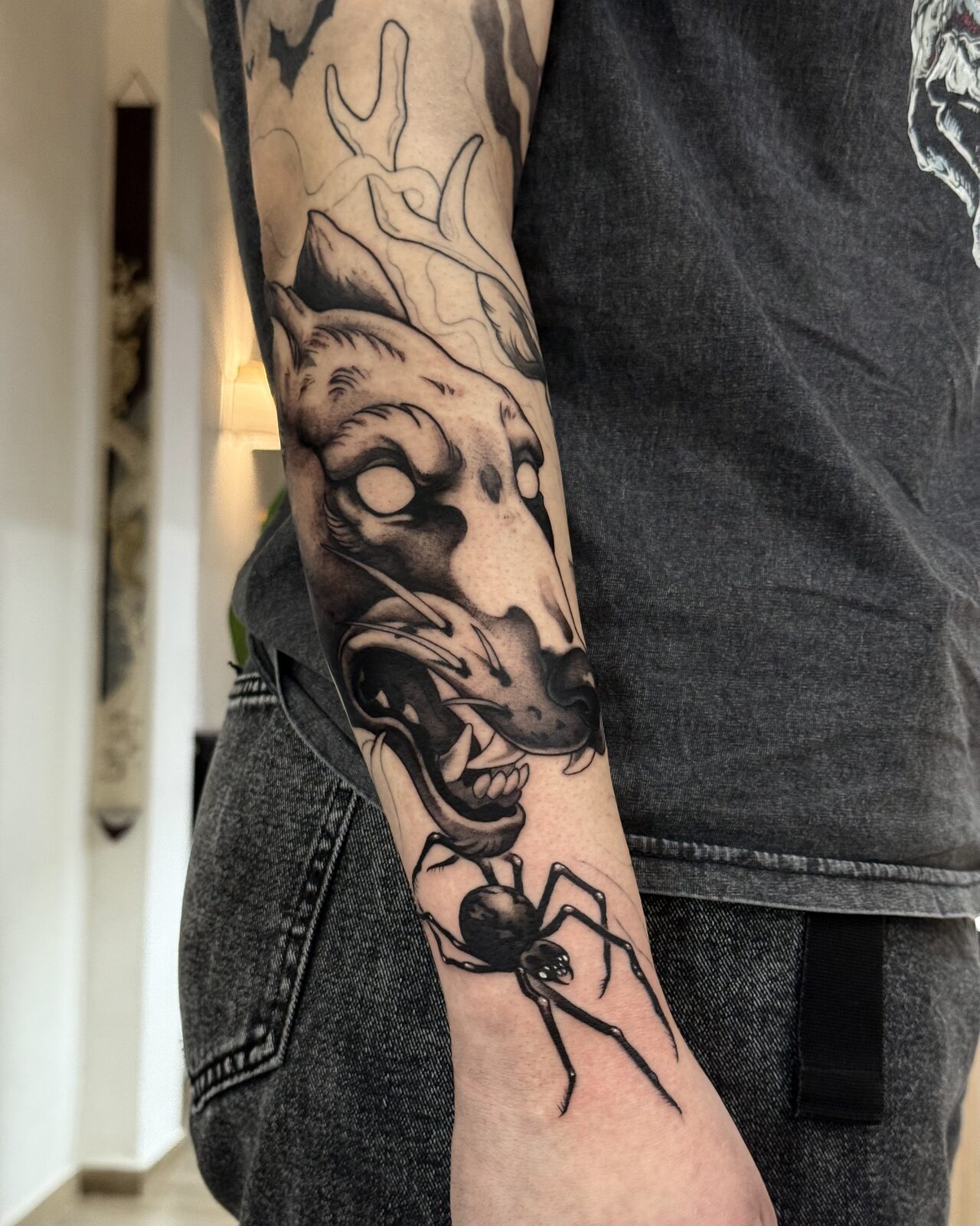 Calavera de animal con araña en blackwork en el antebrazo