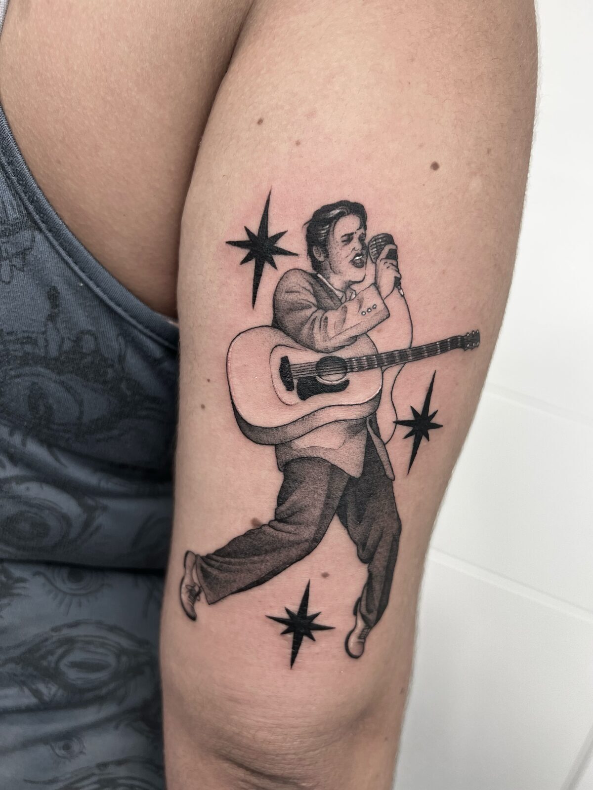 Cantante de rock con guitarra y estrellas en el brazo