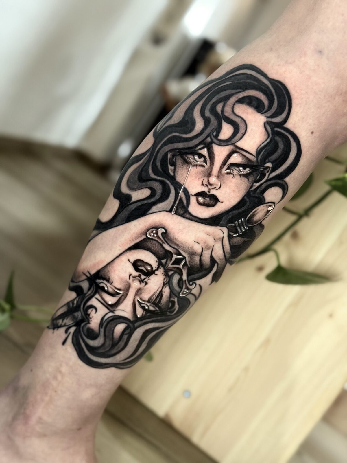 Dos chicas en espejo en blackwork en el brazo