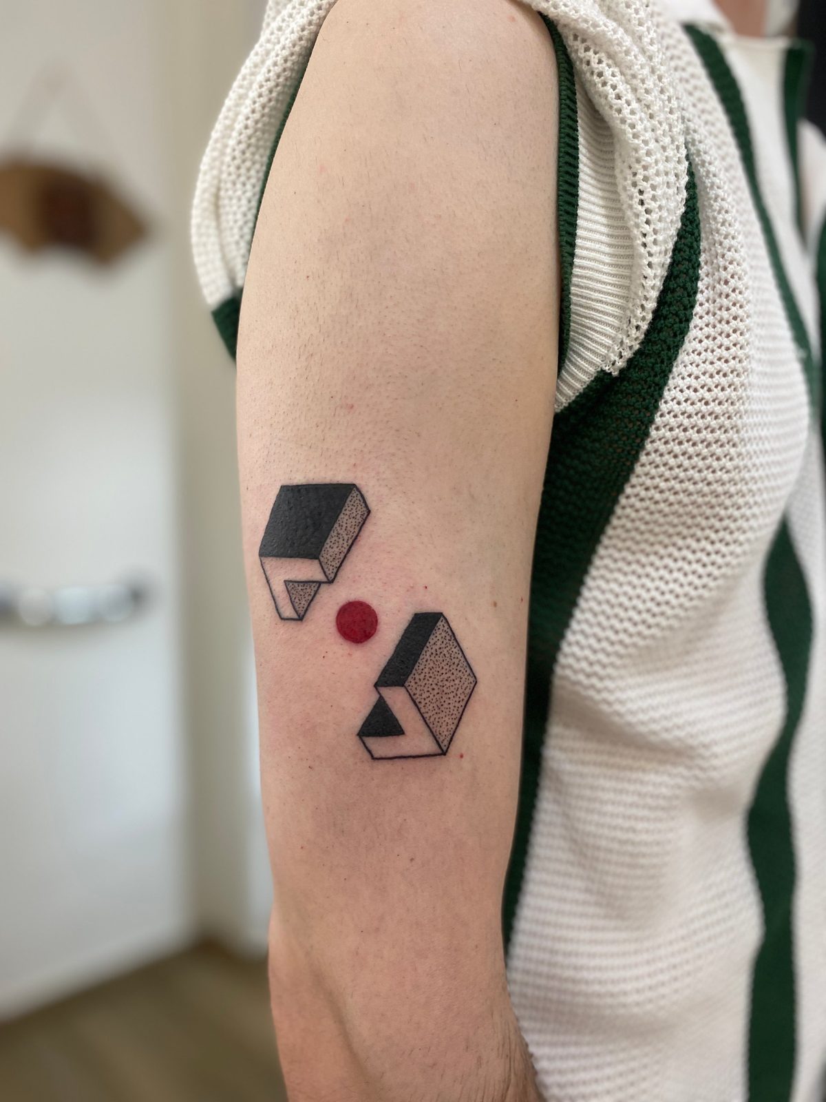 Dos formas geométricas en 3D con punto rojo en el brazo