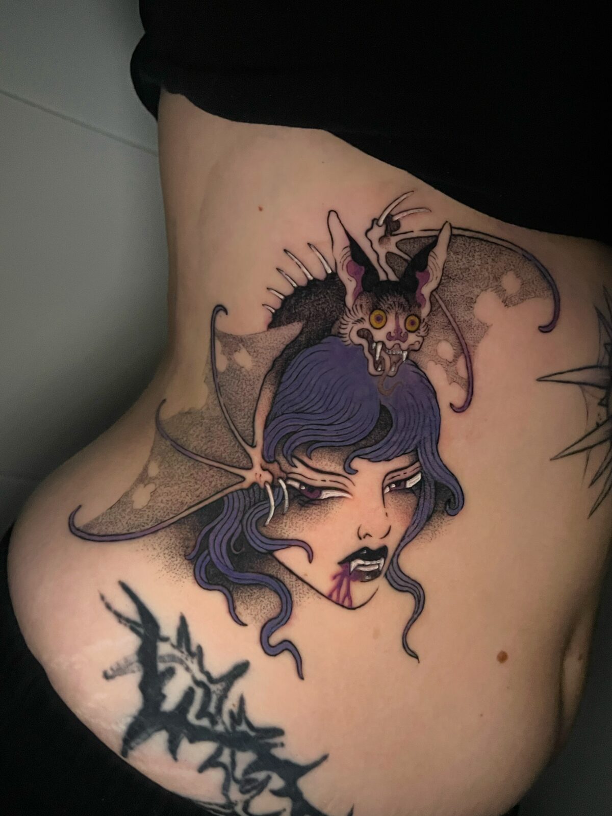 Rostro de mujer con murciélago y pelo lila en el costado
