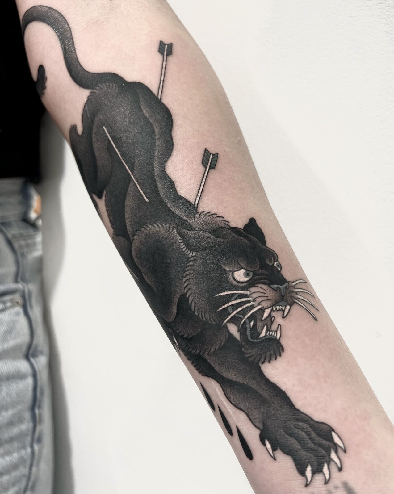 Pantera negra atravesada por flechas en el antebrazo