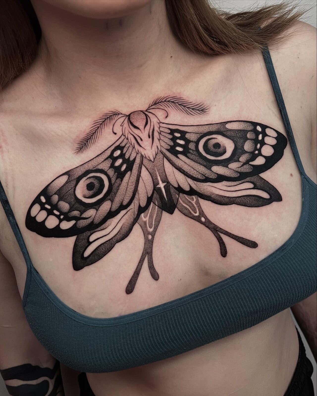 Polilla en blackwork de lado a lado del pecho