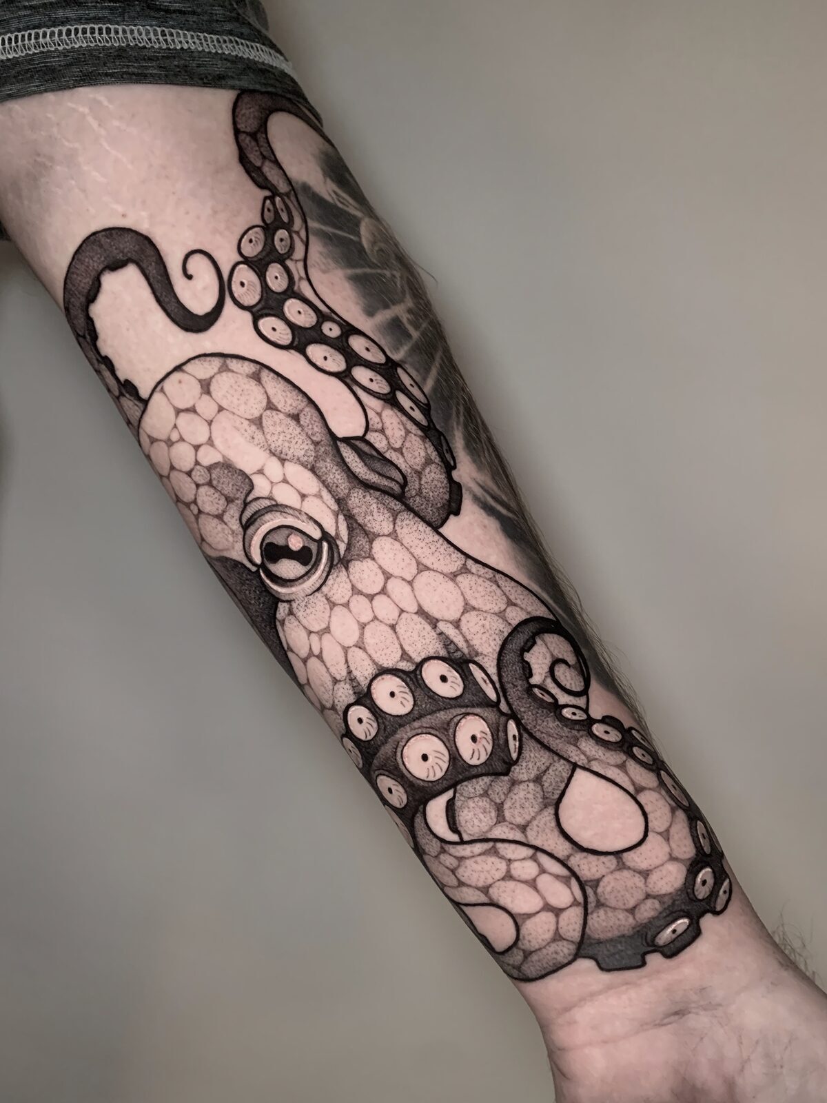 Pulpo en negro y grises en el antebrazo