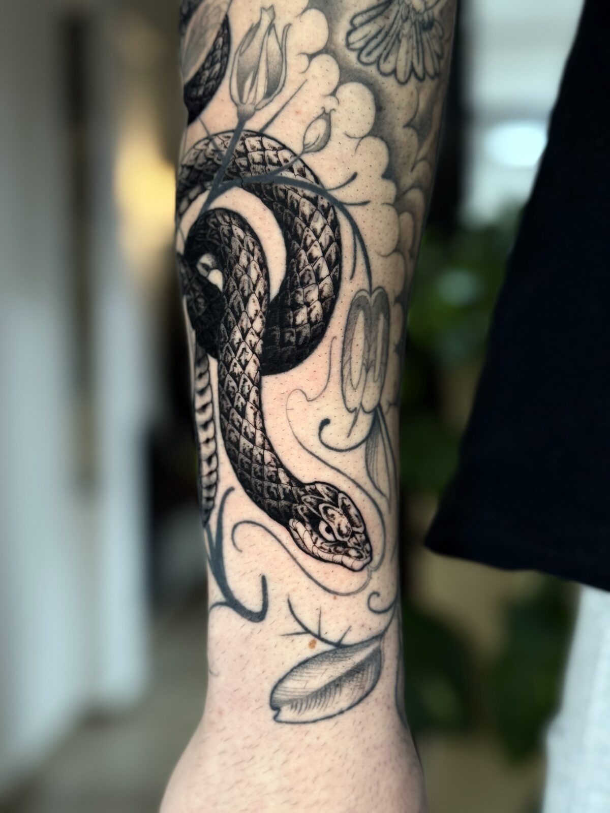Serpiente en negro en el antebrazo