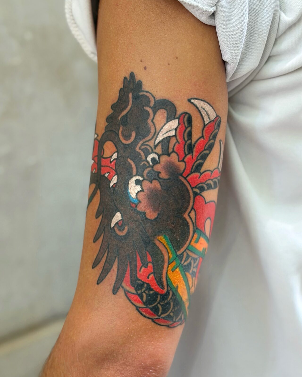 Dragón japonés en negro y rojo en el brazo