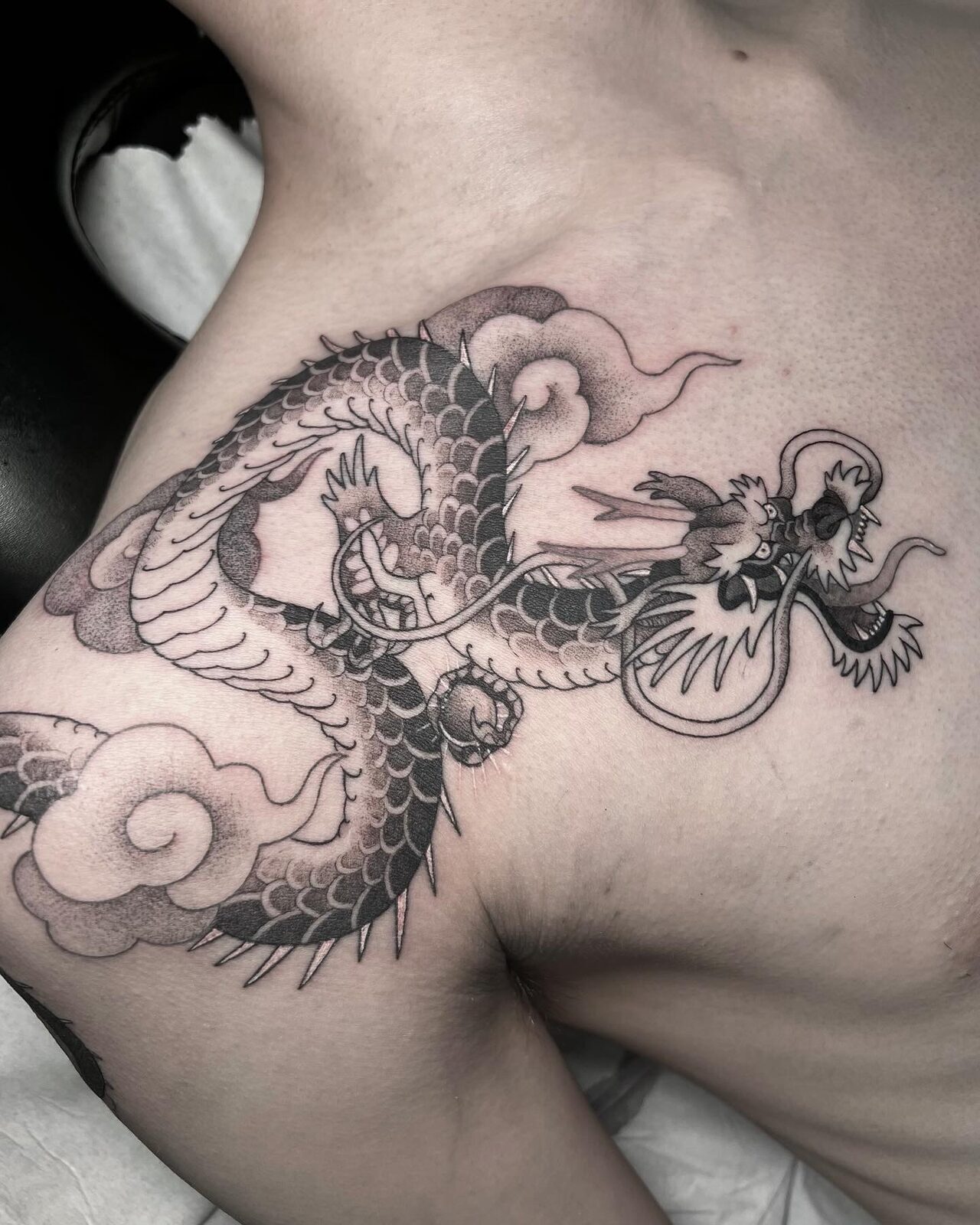 Dragón japonés entre nubes en el hombro