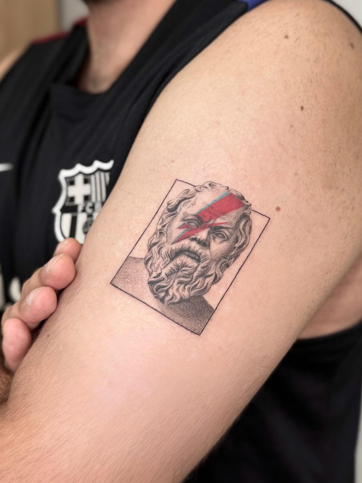 Busto de estatua griega con franja roja en el brazo