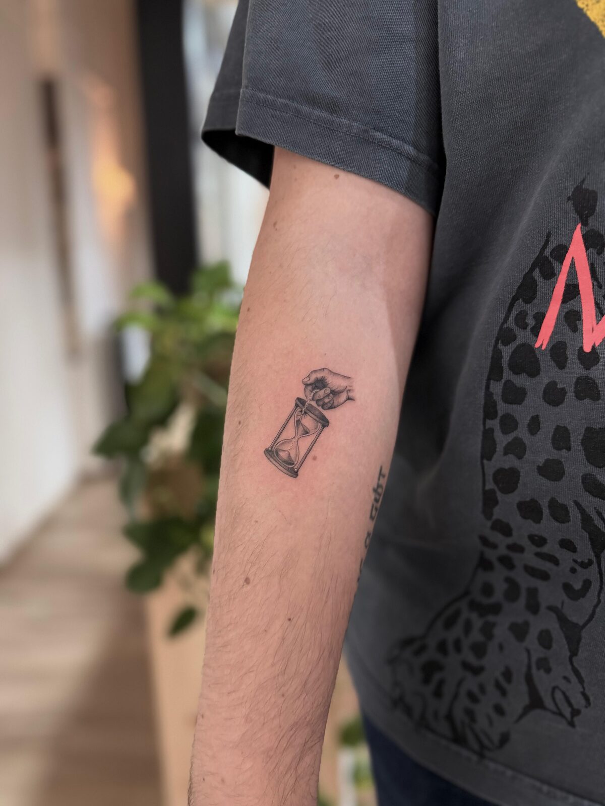 Reloj de arena diminuto en microrealismo en el antebrazo