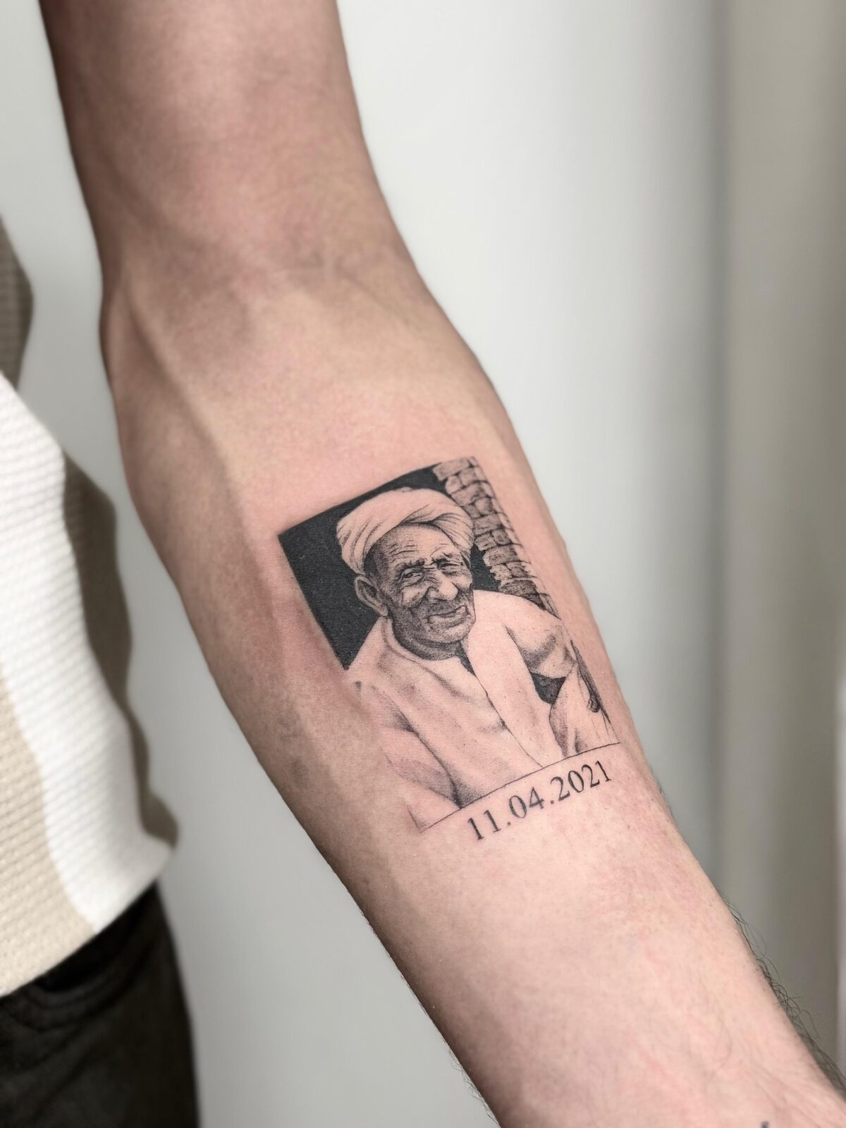 Retrato en microrealismo con fecha conmemorativa en el antebrazo