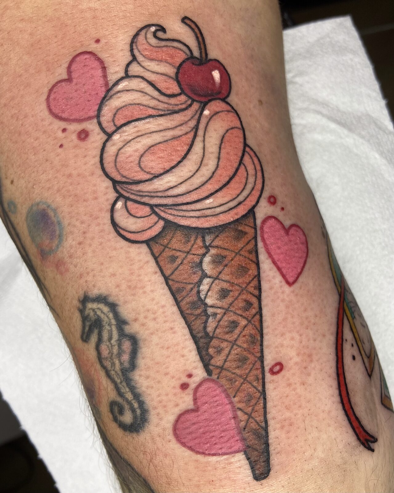 Helado con cereza y corazones en estilo neotradicional en la pierna