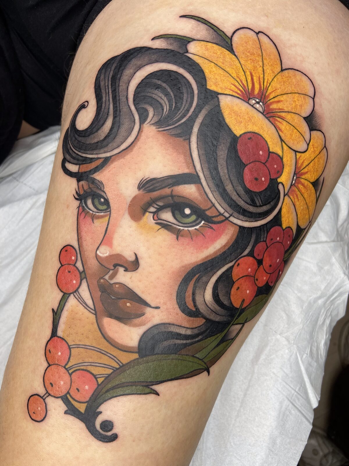 Mujer con flores amarillas y bayas rojas en estilo neotradicional en la pierna