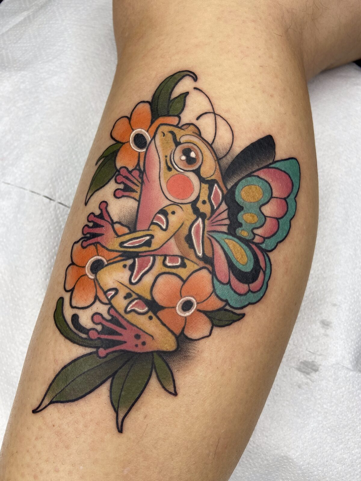 Rana con alas de mariposa y flores en la pierna